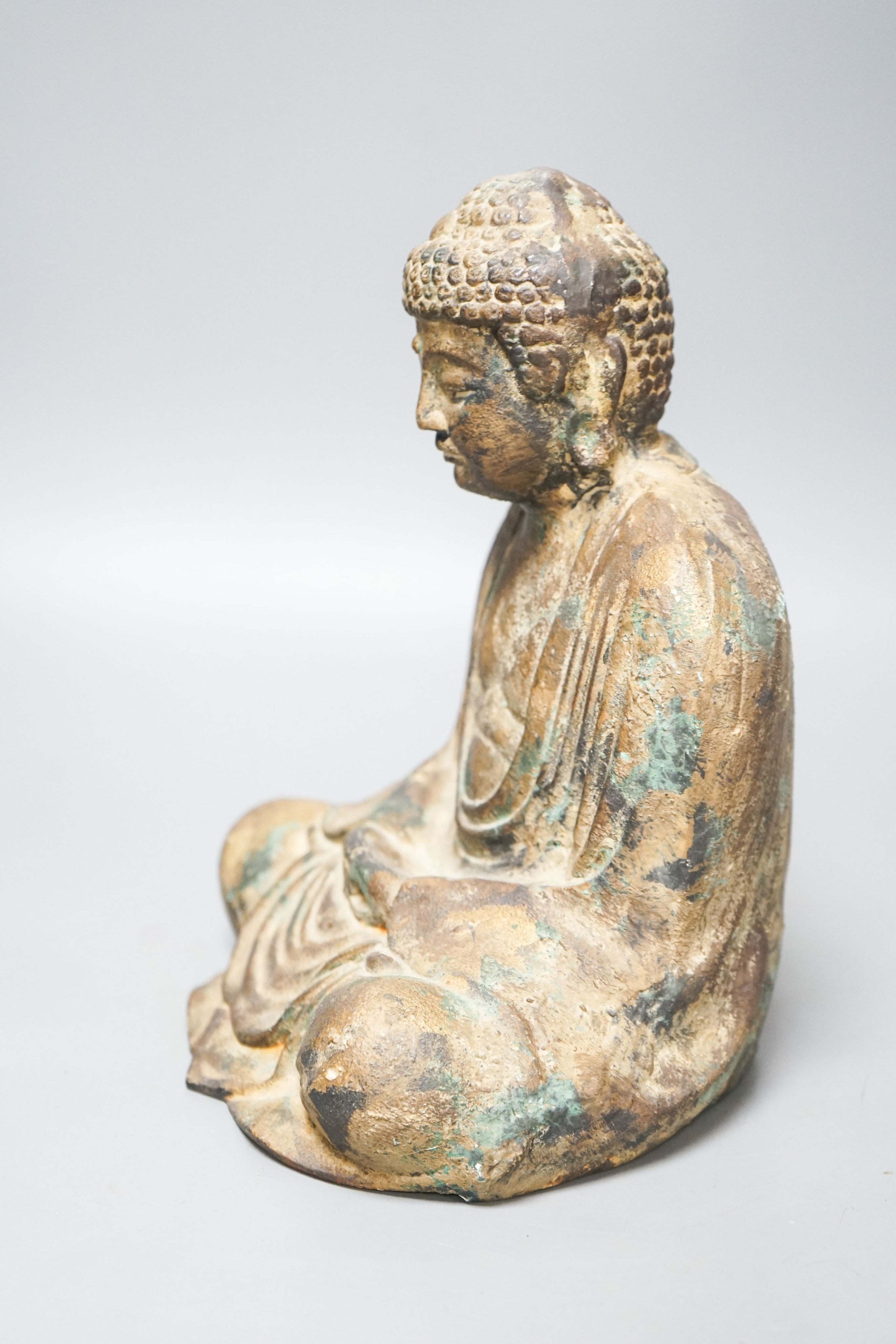 A South East Asian cast iron figure of a seated Buddha 28cm